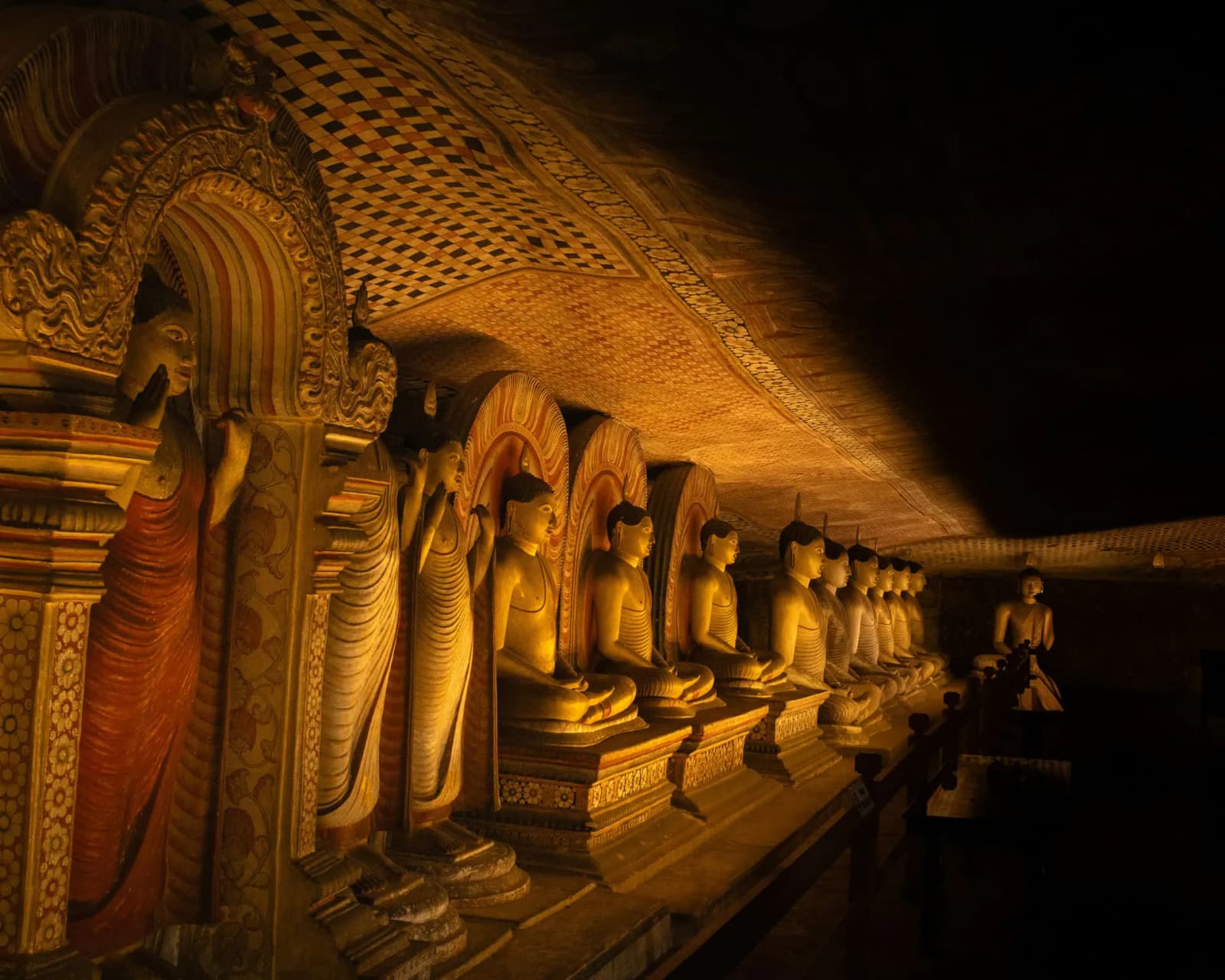 Golden Buddha statues lining the painted caves of Dambulla